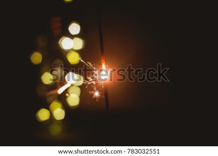 Abstract blur sparklers for celebration christmas,happy new year,party,festival background,Motion Blurred by wind Sparklers with pentagon bokeh background.Winter Dark vintage night  film grain style.