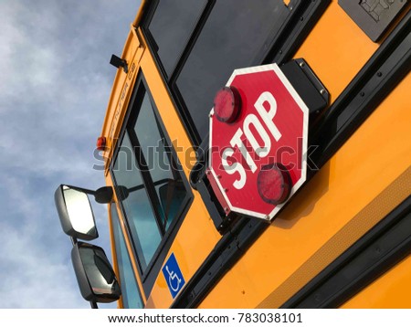 Yellow school bus, stop sign, handicap sign.