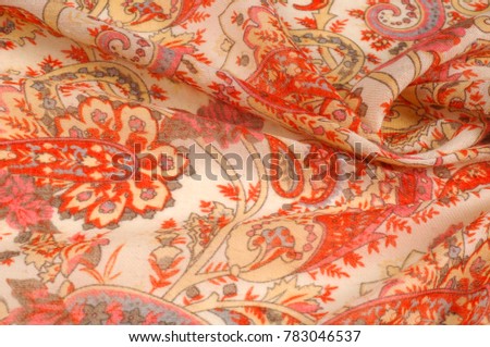 Texture, pattern, background. Silk fabric - paisley on a beige background. This beautiful silk border print has paisley and floral print in orange and grey on a natural colored background.