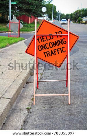 Yield to oncoming traffic construction sign on the road.
