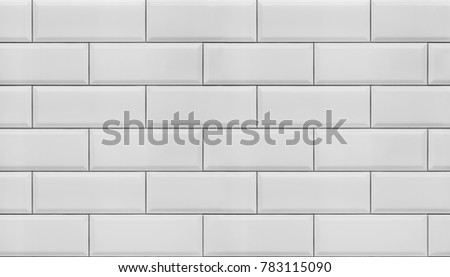 Image of a wall lined with white tiles with beveled edges, for use as a seamless background.