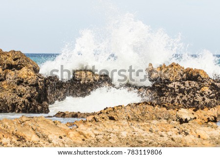Waves breaking over rocks on a warm sunny day at the coast in Nelson Mandela bay