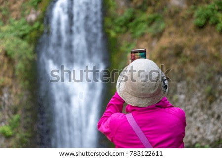 Tourist taking a picture of waterfalls.