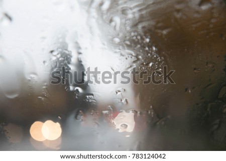 rainy days,rain drops on the window with traffic blur. Blurry car silhouette