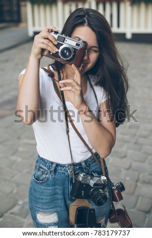portrait of young pretty woman with retro camera  outside 