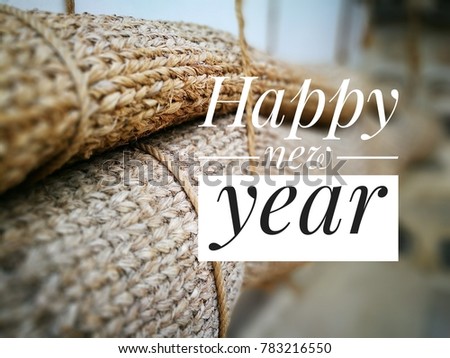 Image of white and black texts of good happy new year welcoming 2018 over blur image of decor mat made of woven straw.  Selective focus.