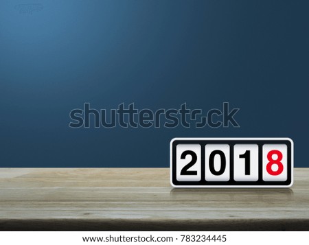 Retro flip clock with 2018 text on wooden table over light blue gradient background, Happy new year concept