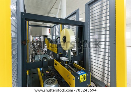 Strapping Machine for Industrail Packaging Line, Modern machine for packaging line in factory, Industrial and technology concept. Royalty-Free Stock Photo #783243694