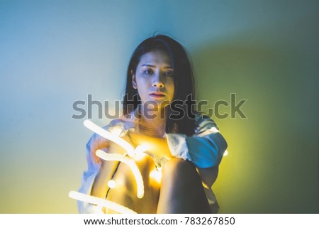 Asian portrait of young beautiful woman with light movement. (slow shutter speed) 