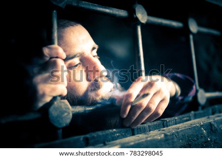 a helpless prisoner between the bars