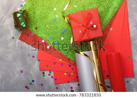 Set of festive decorative paper and ribbon for wrapping gift boxes on grey textured background.