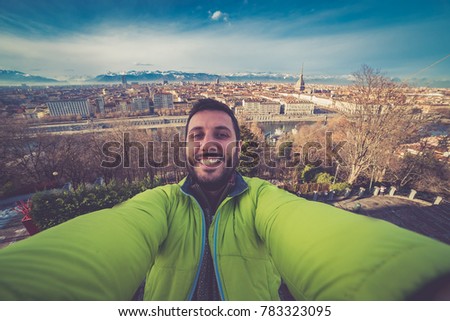 tourism in Turin, Italy. Happy tourist take selfie photo in Turin against landscape cityscape of the city with mole antonelliana and the Alps in background