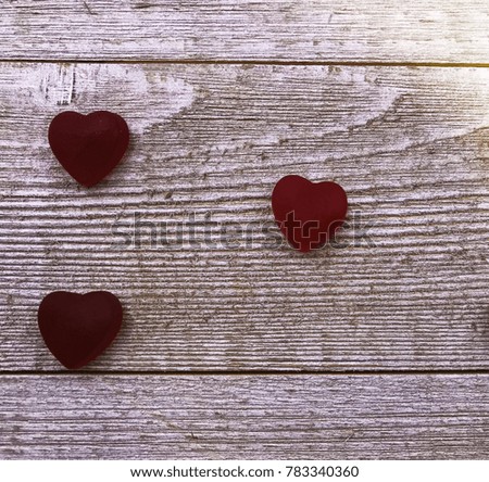 Three red candy Valentine's Day hearts on gray wooden plank background. Space for copy.