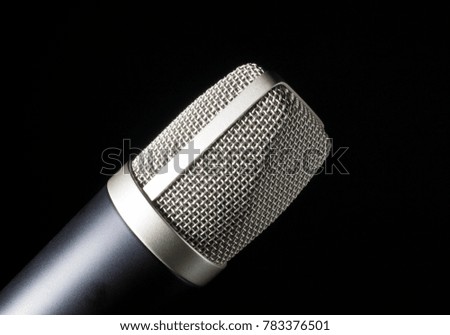 Microphone covered in metal mesh on a black background
