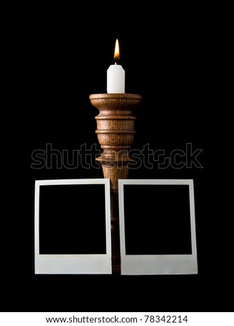 candle and old pictures on a black background