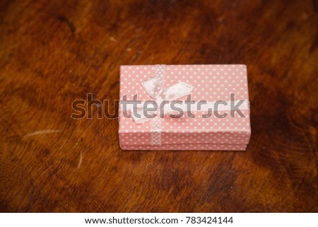 Pink gift box on wooden background