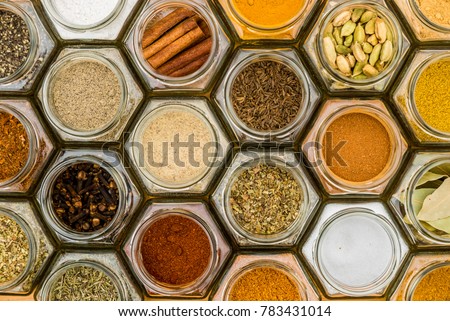 Colorful herbs and spices in hexagonal glass jars. Natural colors and top view. Horizontal picture.