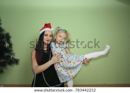 Christmas. a family. girl and girl smiling at the Christmas tree. on a green background. we pull the sock on ourselves. New Year's choreography. preparation for the morning performance