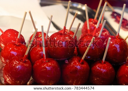Sweet candy Apple. Sweets  glazed paradise apples on sticks for sale on farmer market or country fair. Sugar apple with red icing. 