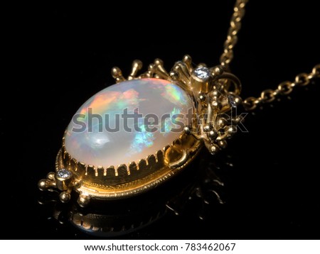 Closeup of a pendant of a necklace made of gold, opal gemstone