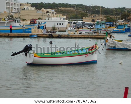 Brightly Colored Fishing Boats at Malta with people taking pictures in background