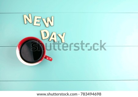 red mug, coffee, word a new day on a turquoise background