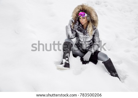 Young woman winter portrait. Winter fashion model with ski suit and goggles. Attractive young woman in wintertime outdoor. Mountains, white snow in magic winter day. Royalty-Free Stock Photo #783500206