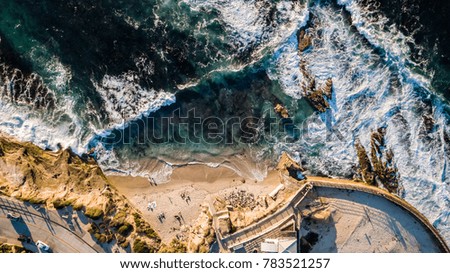 Drone view of the Children's Pool in La Jolla San Diego with waves hitting the seashore