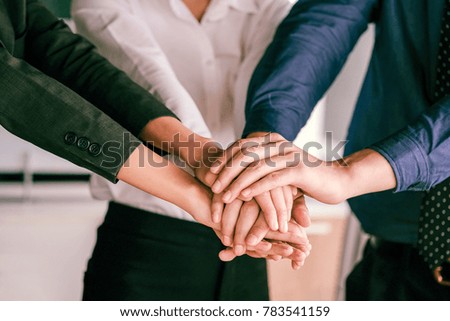 Image of businesspeople hands on top of each other as symbol of their partnership, great teamwork, successful business. Cropped image of young business team holding hands together.