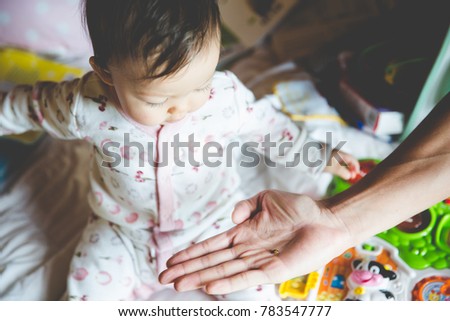 Little Girl Looking at Ladybug in Dad's Hand