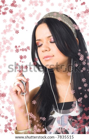 christmas picture of smiling brunette listening music with snowflakes