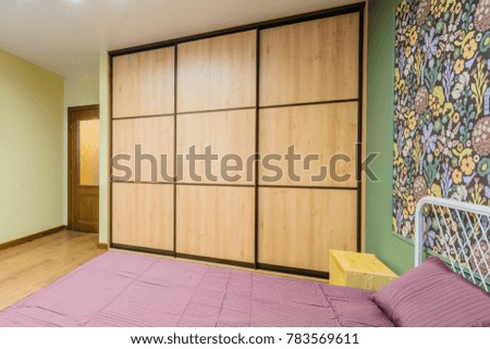 Interior bedroom with a large double bed with bedside tables on a background of modern wallpaper