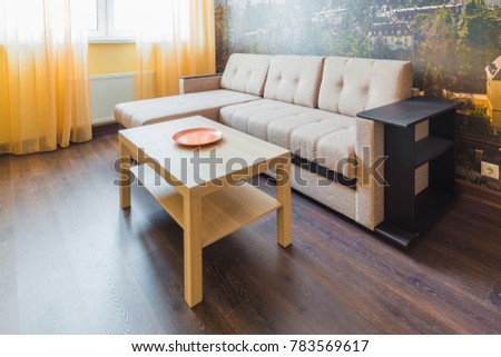 The interior of the living room in orange tones with a coffee table and sofa