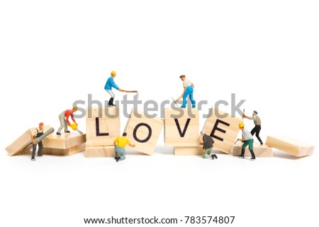 Miniature people : Worker team building word " Love " on wooden block with white background , Valentine's day concept