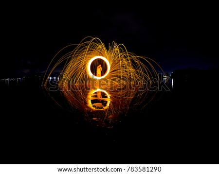 golden yellow light lines of steel wool with long exposure, speed motion abstract background in the dark night