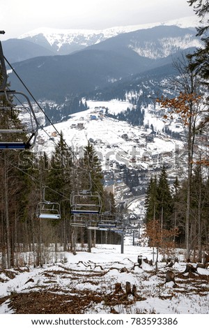 Ski lift and ski piste among of the forest in ski resort in Carpathians