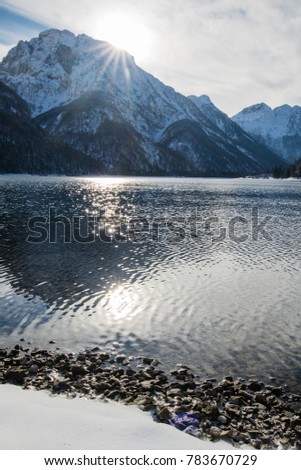 beautiful winter snowy scenery reflection on lake lago del predil in julian alps, italy