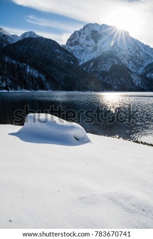 wonderful winter scenery on mountain pass lake lago del predil in snowfall and sunny weather, julian alps, italy