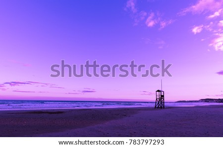 Ultra violet nediterranean beach sunrise with lonely lifeguard wooden tower, Ultra Violet style Royalty-Free Stock Photo #783797293