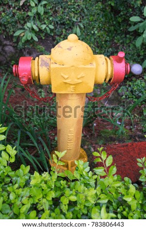 Yellow Fire hydrant on green brushwood for high pressure water pumps designed to increase the fire fighting capacity