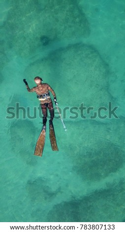 Photo of diver as seen from above swimming in turquoise clear tropical waters 