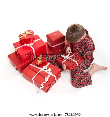 Young boy in pajamas surrounded by gift boxes