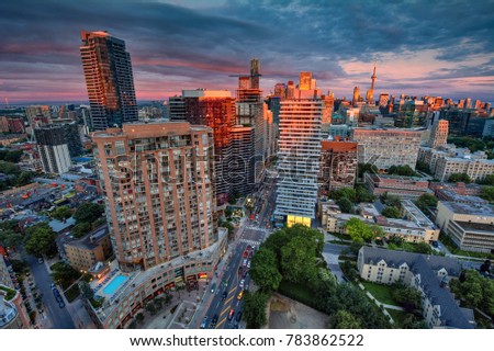 Cityscape at sunset, buildings painted orange by the sky's colours
