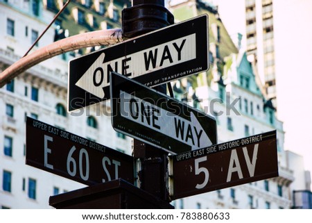 Various streets signs pointing in different directions. This photo was taken in New York City, America