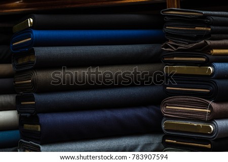Suit fabrics with dark color on a fabric shop shelf Royalty-Free Stock Photo #783907594