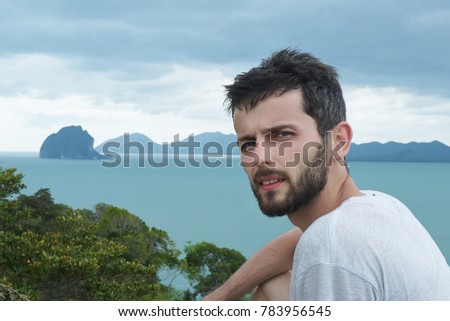                                Self outdoor portrait of young Caucasian bearded brunette man who is travel worldwide.Tired and exhausted American explorer takes picture of himself in picturesque place