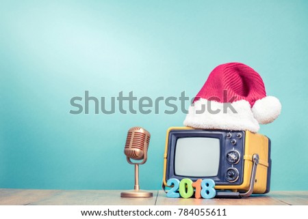 Retro TV in Santa hat with New Year 2018 date and golden microphone front mint green background. Holidays congratulation in mass media concept. Vintage old style filtered photo