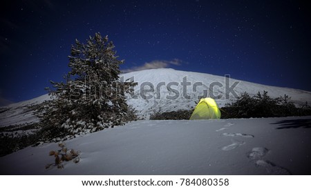 night stars on illuminated yellow tent on the snow and Etna Mount, Sicily