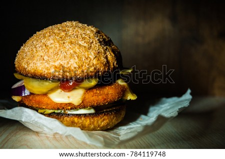 burger on wooden table. on dark wooden background with copy space.