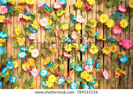 Flower background on bamboo wall.The flower is made by paper it is easy to take care.